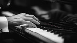 A man is playing the piano with his left hand. Concept of elegance and sophistication, as the man is dressed in a suit and tie while playing the instrument