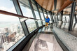 © Cavan Images - Child walking on glass floor above city skyline