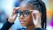 © Elshad Karimov - A young schoolgirl thoughtfully adjusts her new eyeglasses, ensuring clear vision and optimal eye health.