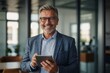 © Tamii - Portrait of happy 50 years old business man executive standing in office using digital tablet. Middle aged businessman manager business owner working on professional finances project looking at camera