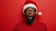 © liliyabatyrova - A man with a red shirt and a Santa hat is looking surprised