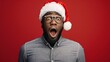 © liliyabatyrova - A man wearing a Santa hat and glasses is looking surprised