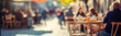 © Ilia - Blurred background of People sitting at tables in outdoor cafe, on bustling street. Relaxed atmosphere, featuring individuals enjoying coffee and casual conversation in lively city environment.