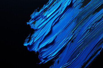 Wall Mural - bright blue brush stroke of paint on black background