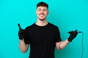 Tattoo artist caucasian man isolated on blue background showing and lifting a finger in sign of the best