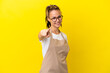 © luismolinero - Restaurant waiter Russian girl isolated on yellow background points finger at you with a confident expression