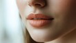 © 69 - Close-up of a young woman lips after a permanent makeup procedure, a soft peachy shade enhancing her natural beauty.