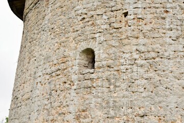 Part of the wall of an ancient stone fortress with a window for shooting