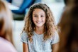 © id512 - Smiling young girl with curly hair in a school classroom, childhood education and happiness concept