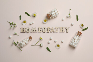 Canvas Print - Word Homeopathy, pills and chamomiles on beige background, flat lay