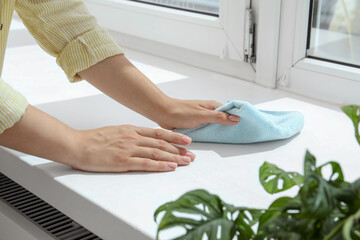 Poster - Woman cleaning windowsill at home, closeup view