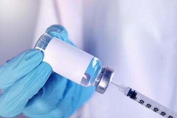 Wall Mural - Nurse filling syringe with medication from glass vial, closeup