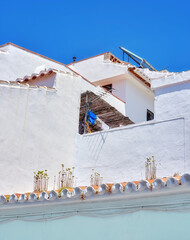 Ancient, city and house building for architecture with windows, wall structure and travel location of tourism. Vintage, property and fence, balcony view and blue sky history culture of Spain holiday