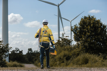 Fototapete - Man engineers holding tools box and rope to maintenance working in wind turbine. Renewable energy power wind turbine. Technology protect environment reduce global warming problems.