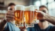 © Suphawan - A group of colleagues celebrating with pints of beer, raising their glasses in cheers during an after-work happy hour.