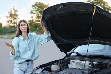 Wall Mural - Stressed woman standing near broken car outdoors