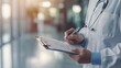 © keetazalay - Close-up of a doctors hand writing a patients diagnosis on a clipboard with a minimalist background, leaving space for text