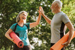 © Maria Vitkovska - Happy senior couple giving high five after successful yoga training outdoors