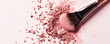 © javu - A close-up of a makeup brush with pink powder scattered on a light surface