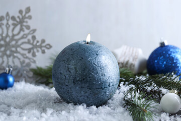 Wall Mural - Burning candle, baubles and fir branches on artificial snow, closeup. Christmas atmosphere