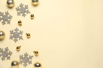 Wall Mural - Christmas balls and snowflakes on beige background, flat lay. Space for text