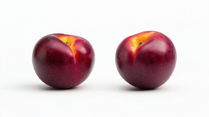 Wall Mural - Two shiny red plums on a white background, showcasing their vibrant color and smooth texture.