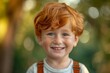 © useful pictures - A cheerful red-haired boy in suspenders beams with happiness, surrounded by a lush, green background on a beautiful afternoon filled with sunlight
