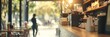 © Maria Mikhaylichenko - Cozy cafe interior with warm lighting, wooden counter, and blurred silhouette of person walking outside, creating inviting atmosphere for coffee lovers.
