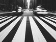 © Creator88 - A bustling city intersection with blurred motion from passing cars and pedestrians, in high-contrast black and white city intersection, street photography, monochrome