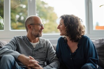 Wall Mural - A man and a woman relaxing together on a couch, possibly at home