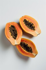 Wall Mural - Fresh papaya cut in half lying on a white surface, ideal for food and still life photography