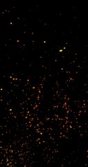 Wall Mural - glowing flying blurred fire sparks on black vertical background.