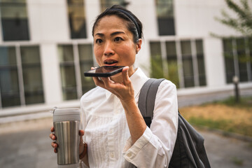 Wall Mural - Angry mature japanese business woman record voice mail on mobile phone