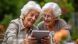 © Kateryna - two elderly people looking at a tablet together while sitting in the garden