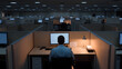 © photo for everything - Lone Worker Sitting at a Desk in a Dimly Lit Office | Solitary Productivity in a Quiet Corporate Environment