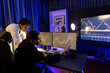 © InfiniteFlow - Two business traders discussing on dynamic stock exchange currency rate risk investment, pointing profit or loss value forecast on pc screens side view at night neon lighting office room. Postulate.