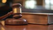 © arsyi_06 - A wooden gavel rests beside a closed law book, symbolizing justice and legal proceedings.
