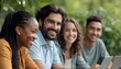 © Photo by mQ - A diverse group of friends—Black woman with braids, Hispanic man with a mustache, Caucasian woman with wavy hair, and Asian man with short hair—smiling and using laptops outdoors among greenery