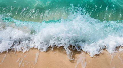 Close up of foamy turquoise ocean waves crashing on a sandy beach