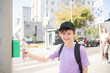 © Ruslan Russland - the boy presses the traffic light button, stands in front of the pedestrian crossing, is about to cross the road