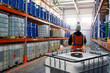 © Grispb - Man standing in fuel warehouse. Storage chemical products. Warehouse with barrels with fuel. Multi-tiered shelving in storage facility. Storekeeper near IBC containers. Fuel warehouse inside hangar