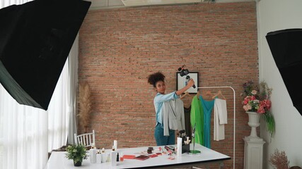 Wall Mural - Woman influencer shoot live streaming vlog video review clothes crucial social media or blog. Happy young girl with apparel studio lighting for marketing recording session broadcasting online.