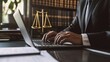 © somchai20162516 - A close-up of a lawyer typing on a laptop, working on a legal document or correspondence