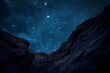 © Six Hen Media - Night sky with bright stars above rugged mountain cliffs.