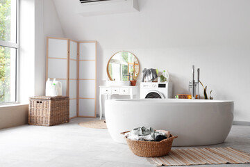 Canvas Print - Interior of light bathroom with bathtub, laundry basket and washing machine