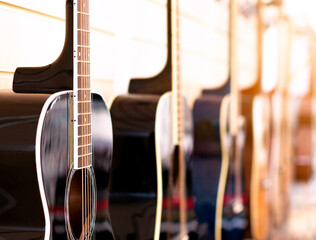 Acoustic guitar abstract background. Acoustic guitars are traditional, unamplified musical instruments with steel or nylon strings. Selective focus on strings of closest grand concert style guitar.