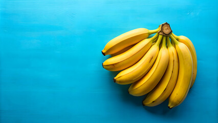 Cluster of ripe bananas on vibrant blue background, bananas, fruit, yellow, healthy, food, bunch, colorful, tropical