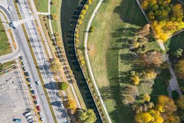 Wall Mural - asphalt road passing through an residential area near water canal. aerial view in sunny autumn day.