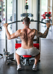 Wall Mural - Fitness man in the gym. Young muscular man workout. Man with sexy strong body, strength and motivation. Fitness man at workout in gym pumping up muscles. Fitness and bodybuilding health.