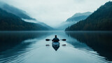 Solo rower navigating a calm lake in a kayak